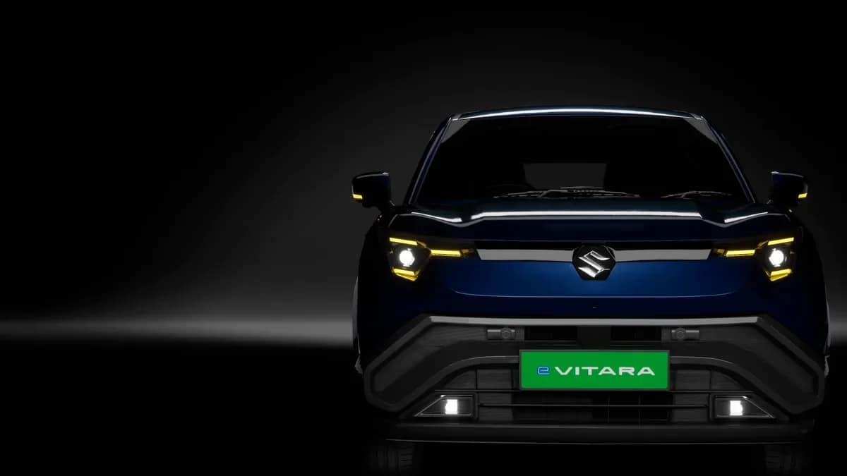 Front view of the Maruti e Vitara with its LED daytime running lights on, against a dark background
