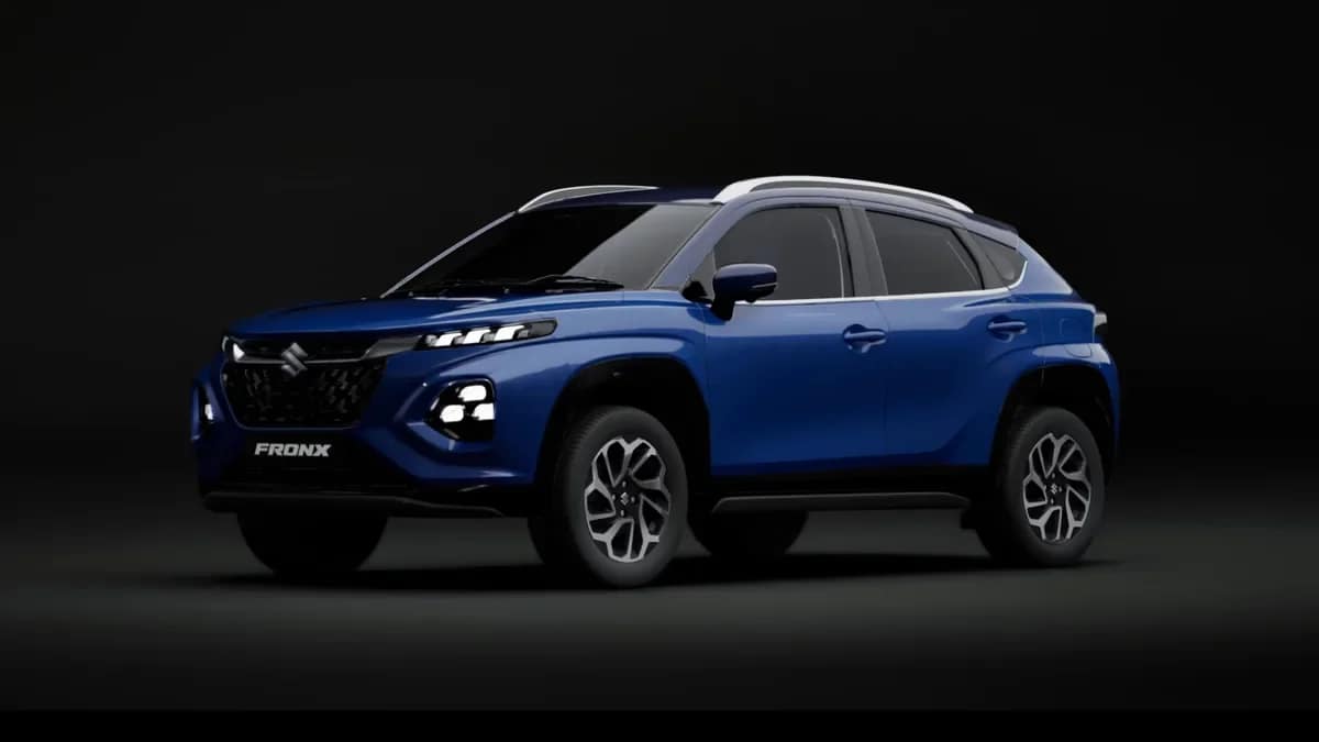 Blue Maruti Suzuki Fronx crossover with a silver roof on a dark studio background, front three-quarter view
