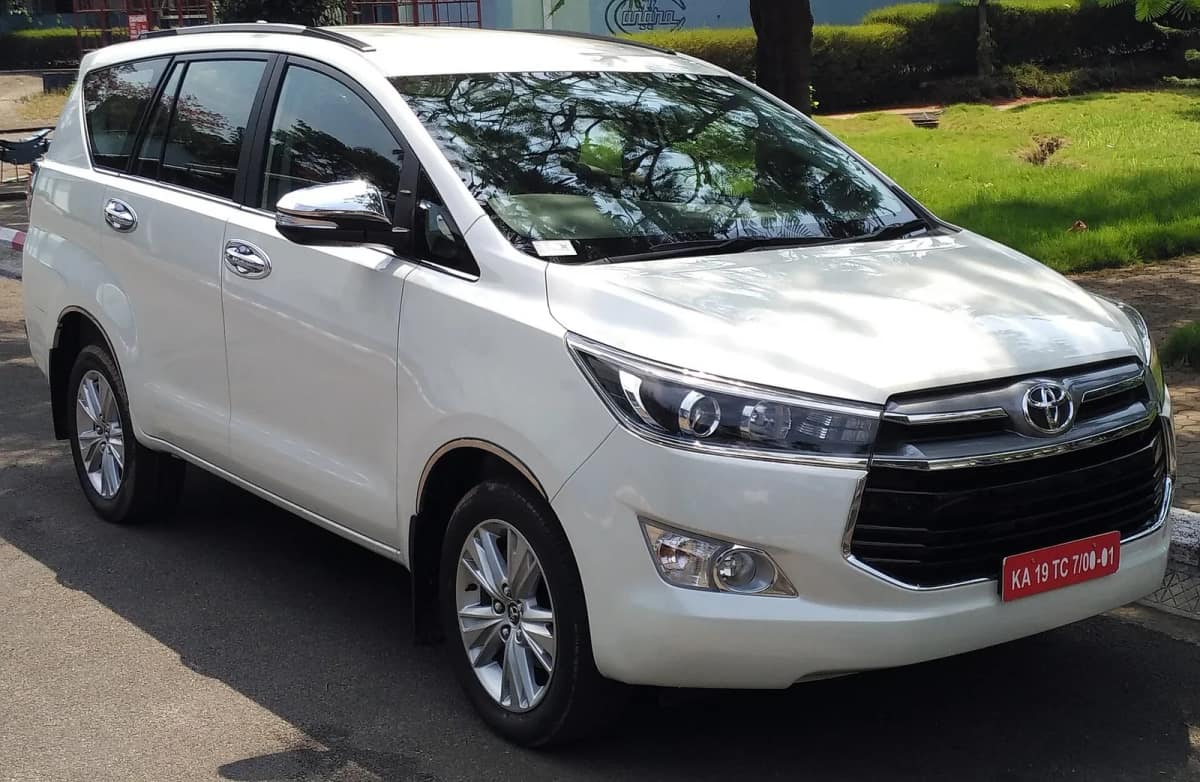 White Toyota Innova Crysta diesel MPV seen from the front right on an Indian road
