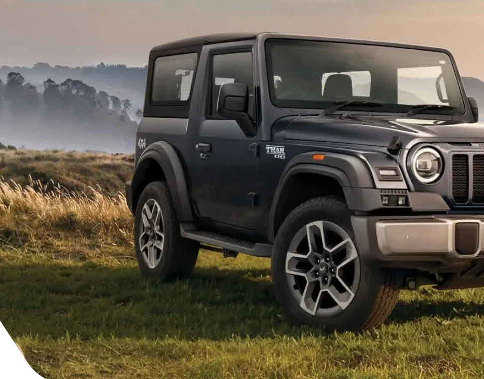 Grey Mahindra Thar OG parked on grass, side view