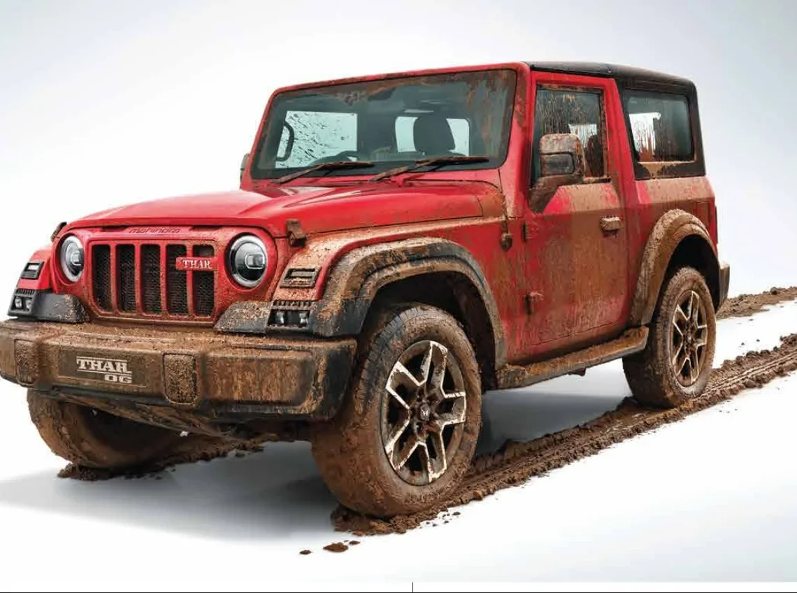 Red Mahindra Thar OG with mud on the body, front three quarter view